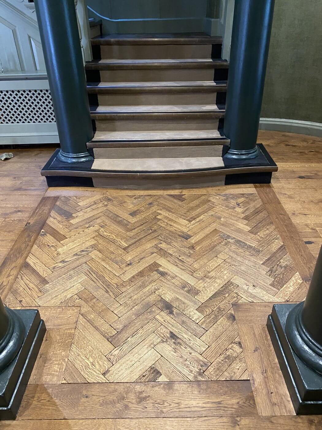 ornate wood flooring leading to staircase
